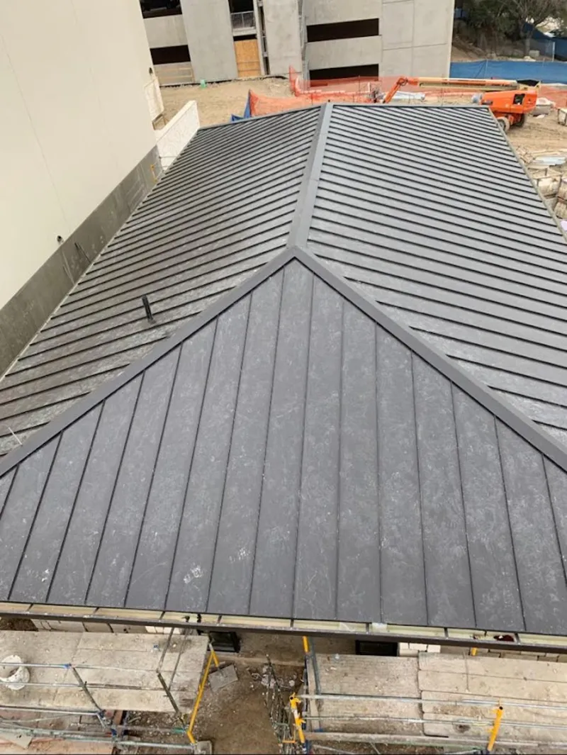 Commercial metal roof construction with crane equipment in Ruidoso